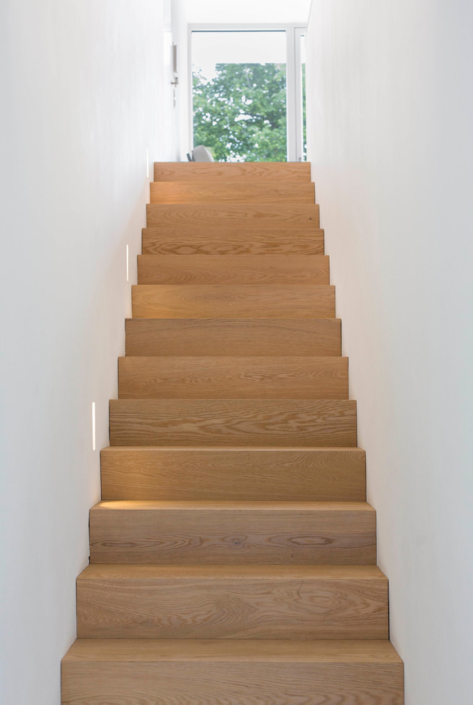 Esempio di una scala a rampa dritta minimalista di medie dimensioni con pedata in legno