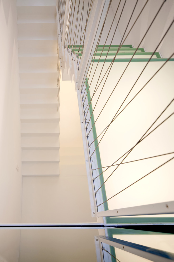 На фото: п-образная лестница среднего размера в современном стиле с стеклянными ступенями и металлическими перилами