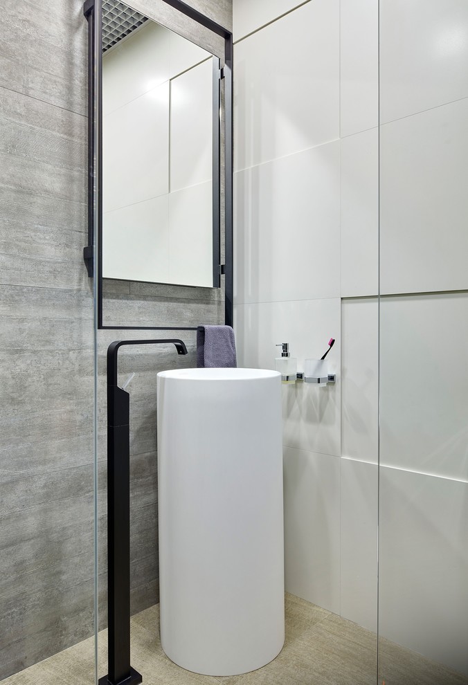 На фото: туалет в современном стиле с серой плиткой, раковиной с пьедесталом и бежевым полом с