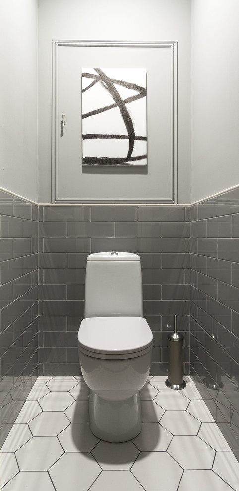 Réalisation d'un WC et toilettes tradition avec WC séparés, un carrelage gris, un carrelage blanc, un mur gris, un carrelage métro et un sol blanc.