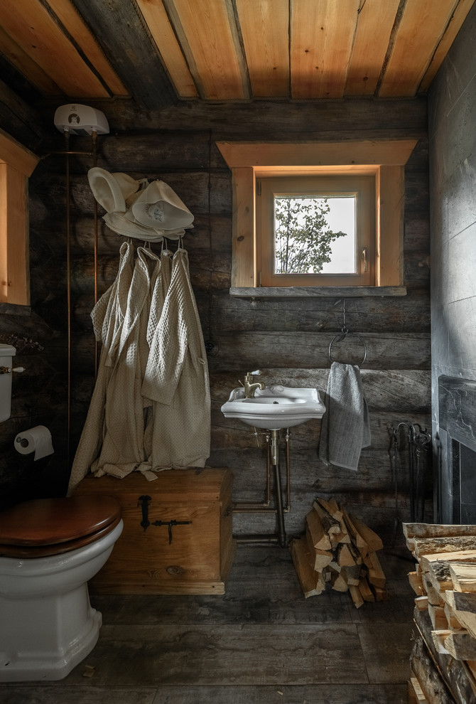 На фото: туалет в стиле рустика с раздельным унитазом, серыми стенами и подвесной раковиной