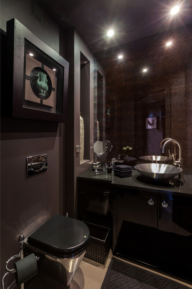 Aménagement d'un WC suspendu contemporain de taille moyenne avec un placard à porte plane, des portes de placard noires, un mur noir, une vasque, un sol marron, un plan de toilette noir et meuble-lavabo encastré.
