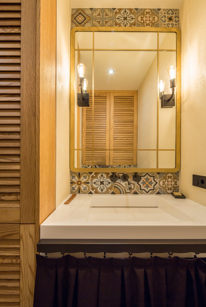 Cette photo montre un petit WC suspendu tendance en bois clair avec un placard à porte persienne, un mur beige, un sol en carrelage de céramique, un lavabo de ferme, un plan de toilette en surface solide, un sol beige et un plan de toilette beige.