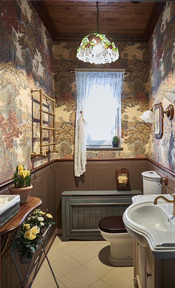 Klassisk inredning av ett toalett, med en toalettstol med separat cisternkåpa, bruna väggar och ett integrerad handfat