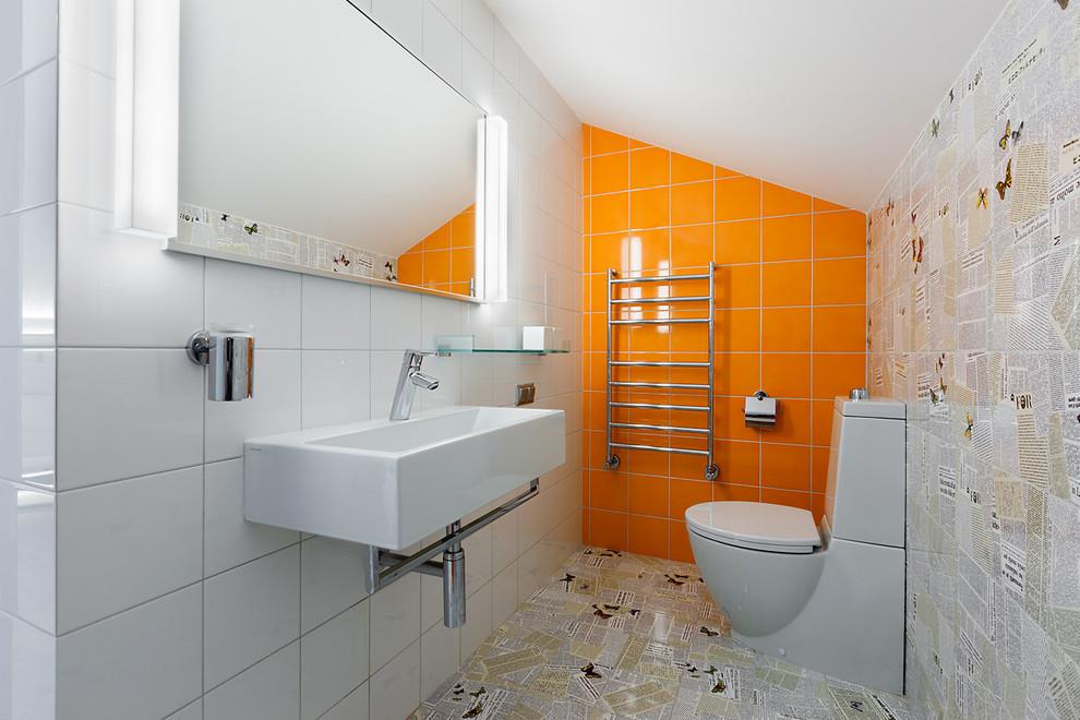 Идея дизайна: большой туалет в современном стиле с керамической плиткой, подвесной раковиной, раздельным унитазом, белой плиткой, оранжевой плиткой и разноцветной плиткой