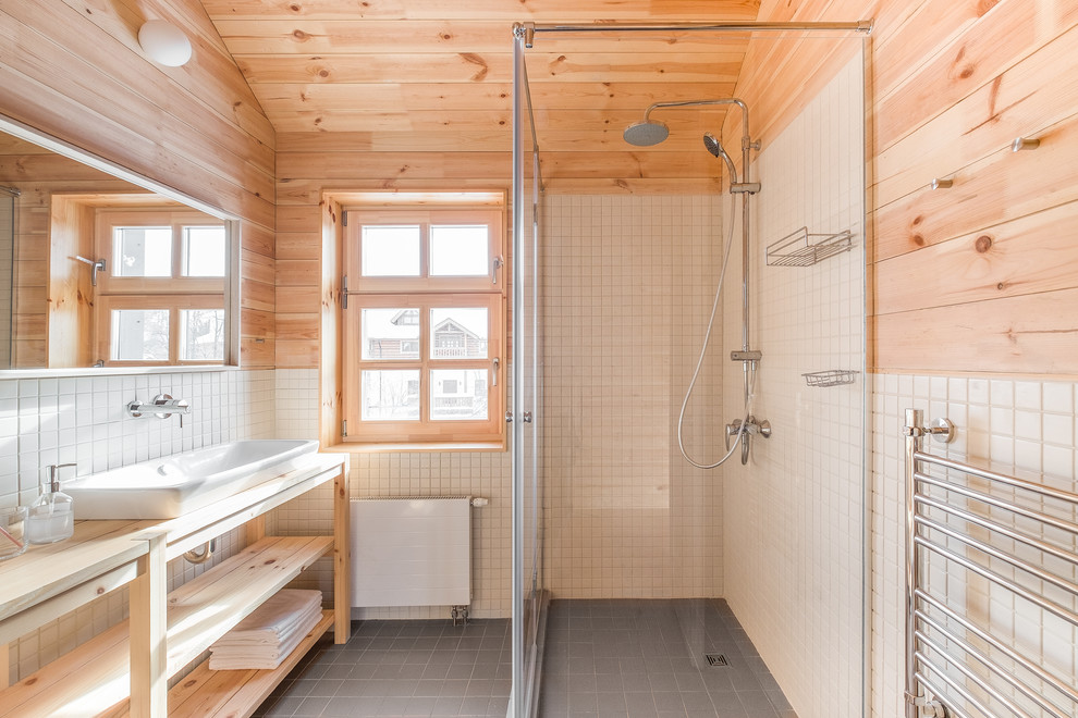 На фото: большая ванная комната в стиле кантри с белой плиткой, керамогранитной плиткой, накладной раковиной и столешницей из дерева