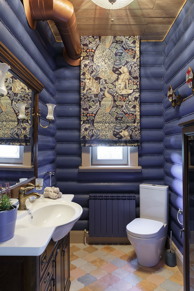 Immagine di un bagno di servizio country con WC a due pezzi, pareti blu e pavimento marrone
