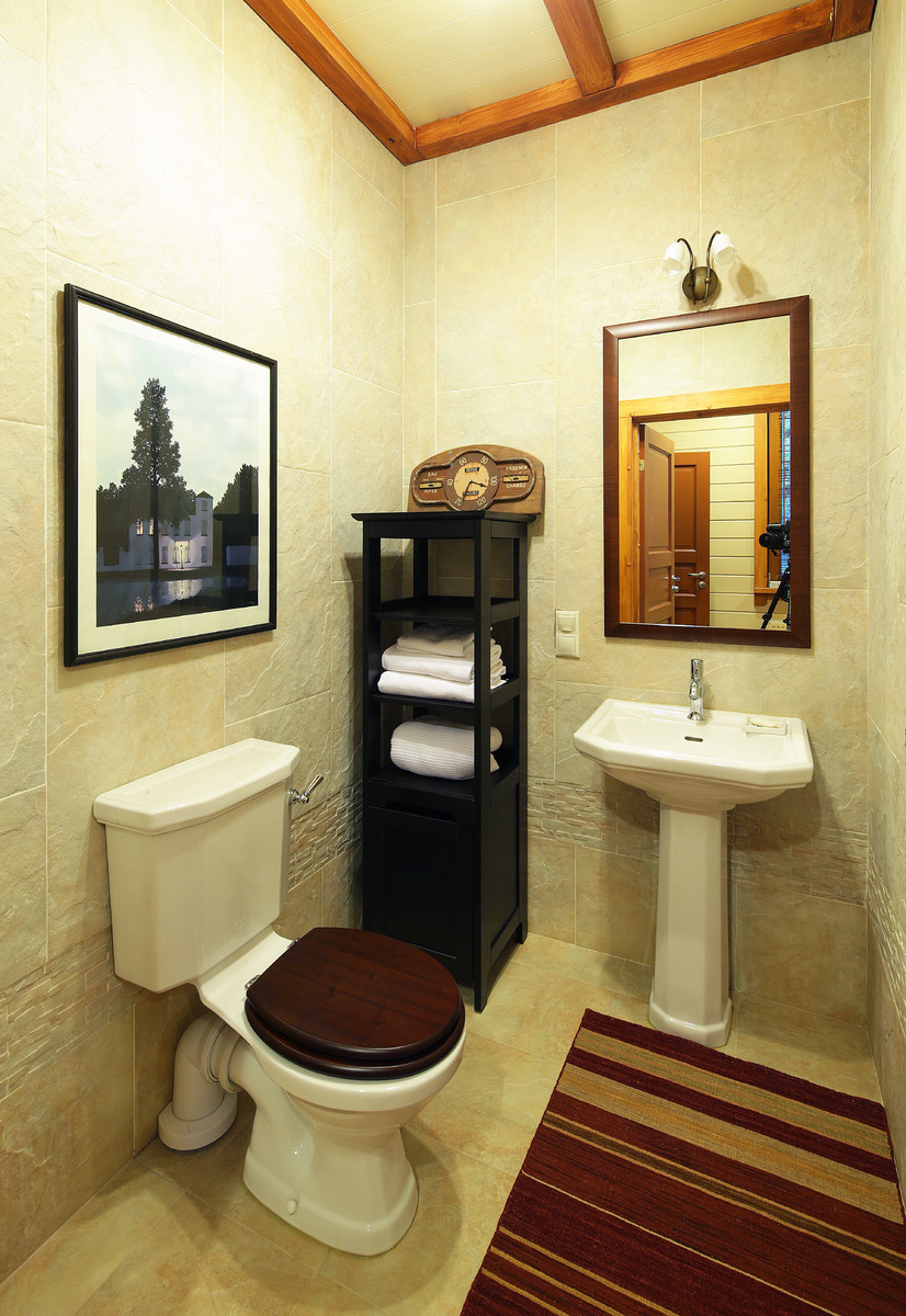 Foto di un bagno di servizio country di medie dimensioni con lavabo a colonna, piastrelle beige, piastrelle in ceramica, pareti beige, pavimento in gres porcellanato e pavimento beige