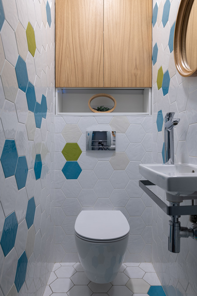 Modelo de cuarto de baño contemporáneo con sanitario de pared, baldosas y/o azulejos blancos, baldosas y/o azulejos multicolor, lavabo suspendido y suelo blanco