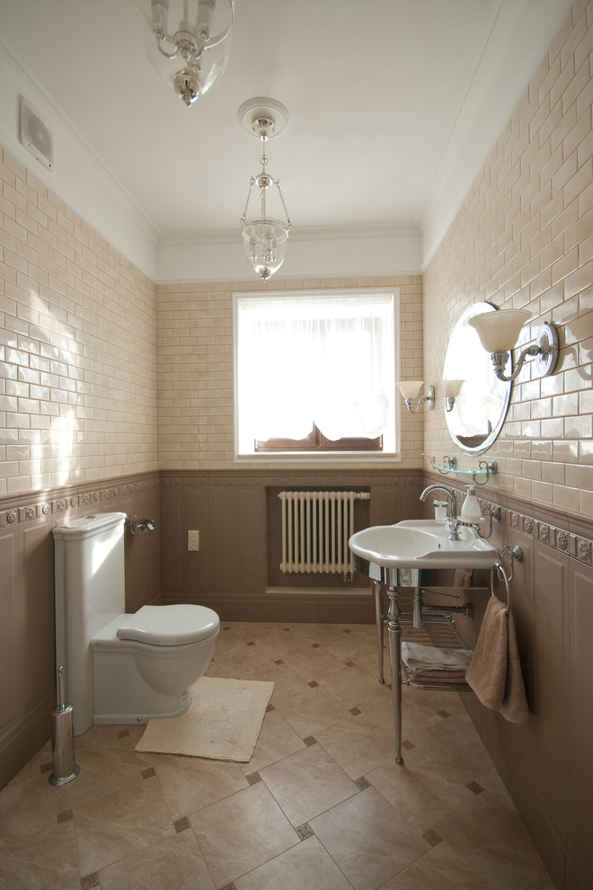 Klassische Gästetoilette mit Toilette mit Aufsatzspülkasten, beigen Fliesen, braunen Fliesen, Waschtischkonsole und braunem Boden in Moskau