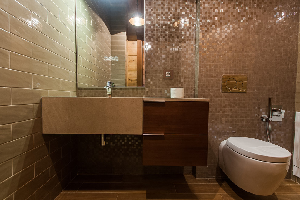 Cette photo montre un petit WC suspendu tendance en bois brun avec un placard à porte plane, un carrelage beige, des carreaux de céramique, un sol en carrelage de porcelaine, un lavabo intégré et un plan de toilette en calcaire.