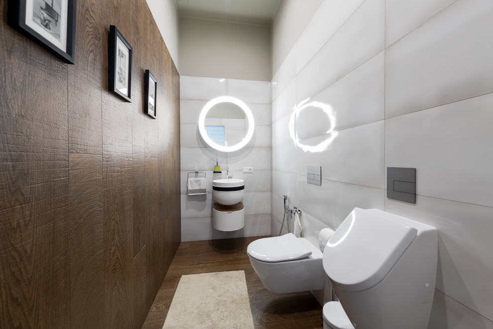 Inspiration for a medium sized cloakroom in Saint Petersburg with flat-panel cabinets, white cabinets, an urinal, porcelain tiles, porcelain flooring, a wall-mounted sink, brown floors, white tiles and brown tiles.
