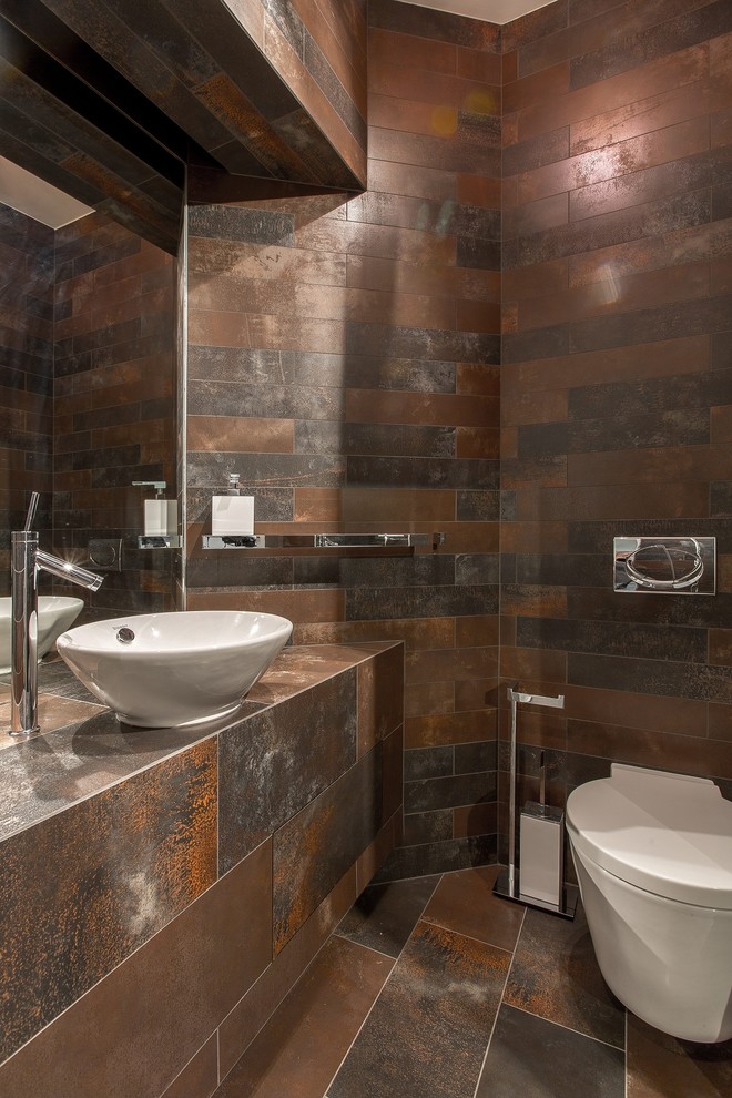 他の地域にあるコンテンポラリースタイルのおしゃれなトイレ・洗面所 (フラットパネル扉のキャビネット、分離型トイレ、ベッセル式洗面器、茶色い床) の写真