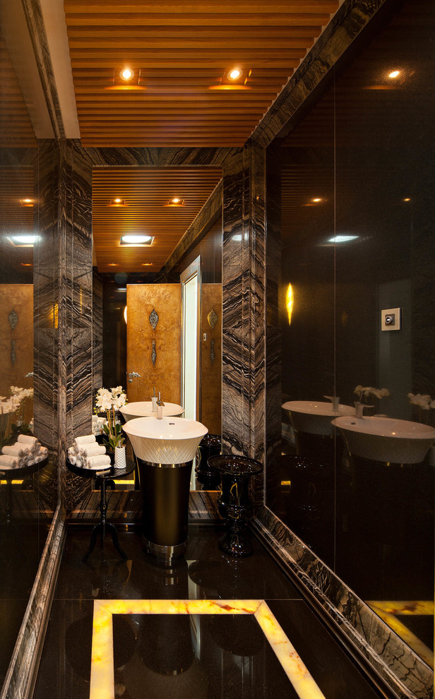 Foto di un piccolo bagno di servizio design con WC sospeso, lastra di pietra, pareti nere, pavimento in marmo e lavabo a colonna