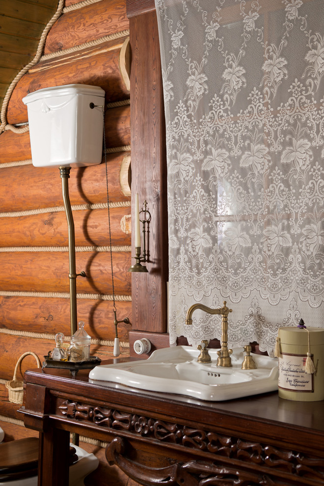 モスクワにあるラスティックスタイルのおしゃれなトイレ・洗面所 (家具調キャビネット、濃色木目調キャビネット、オーバーカウンターシンク、木製洗面台) の写真
