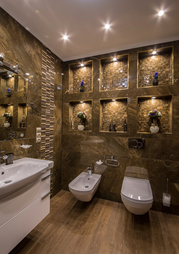На фото: туалет в современном стиле с плоскими фасадами, белыми фасадами, биде, коричневой плиткой, коричневыми стенами, накладной раковиной и коричневым полом