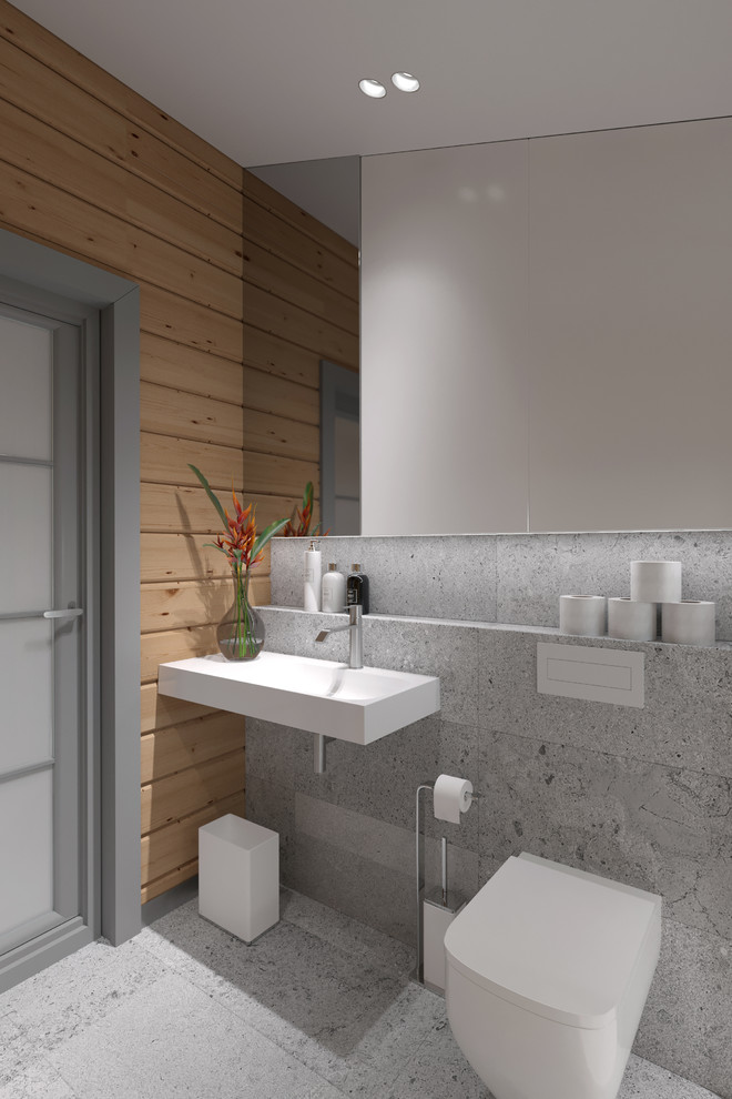 Idéer för små nordiska toaletter, med släta luckor, grå skåp, en vägghängd toalettstol, grå kakel, stenhäll, grå väggar, klinkergolv i porslin, ett väggmonterat handfat, granitbänkskiva och grått golv