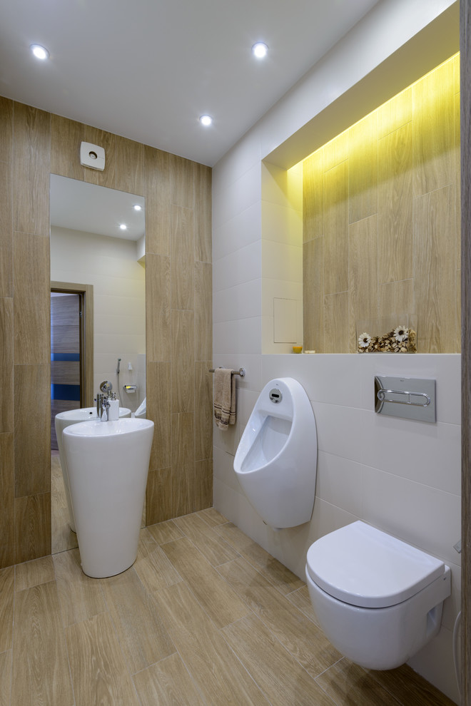 Cette image montre un WC et toilettes design de taille moyenne avec un carrelage beige, un carrelage blanc, des carreaux de céramique, un sol en carrelage de porcelaine, un urinoir, un lavabo de ferme et un sol beige.