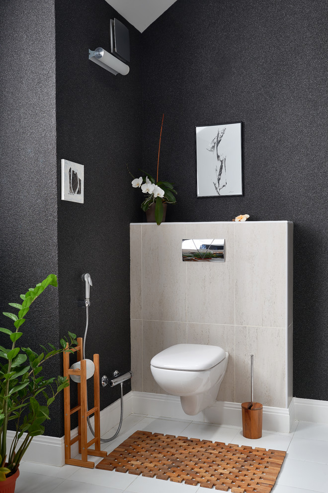Foto på ett funkis toalett, med en vägghängd toalettstol och svarta väggar