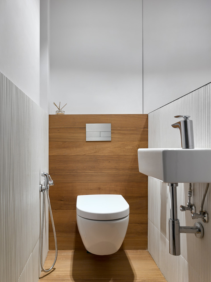 Idéer för funkis toaletter, med en vägghängd toalettstol, vita väggar och ett väggmonterat handfat