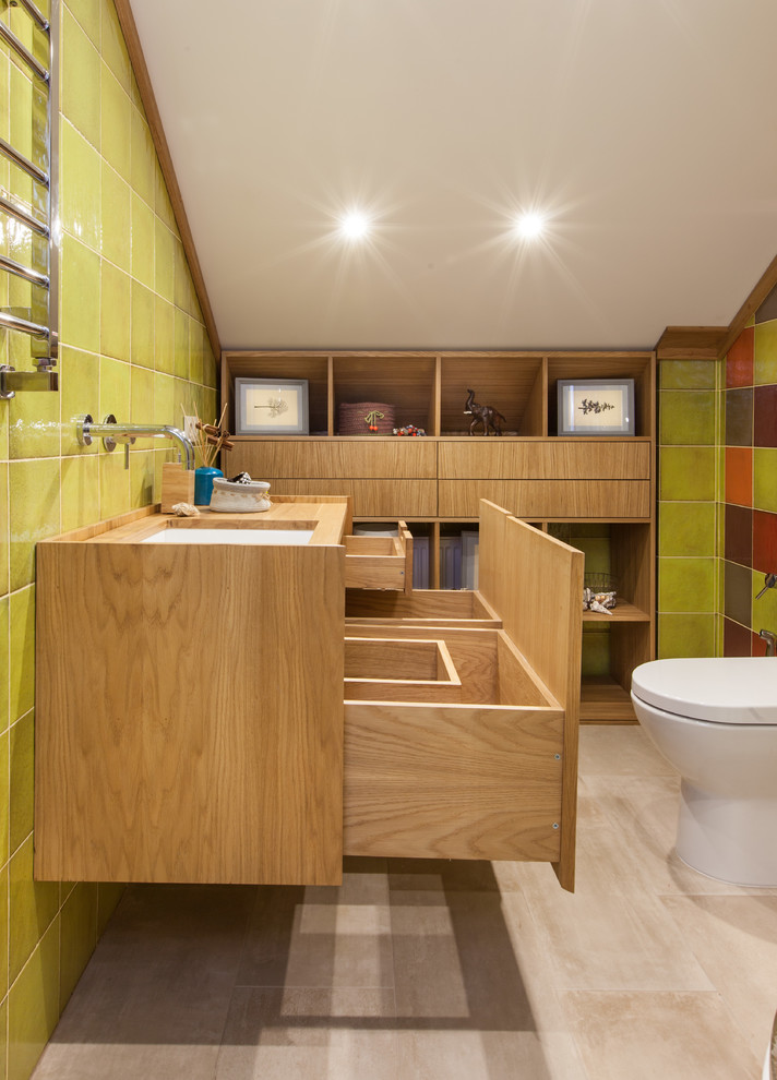 Ejemplo de aseo actual de tamaño medio con baldosas y/o azulejos verdes y lavabo bajoencimera