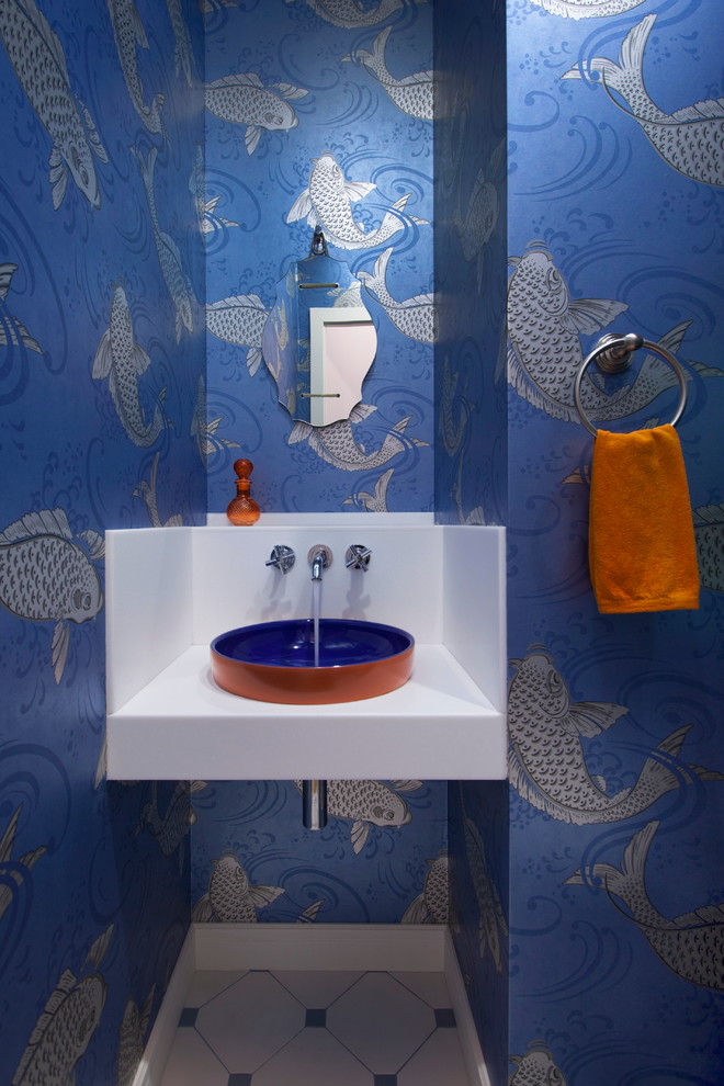 Diseño de aseo actual con paredes azules, encimera de acrílico, lavabo sobreencimera y suelo multicolor