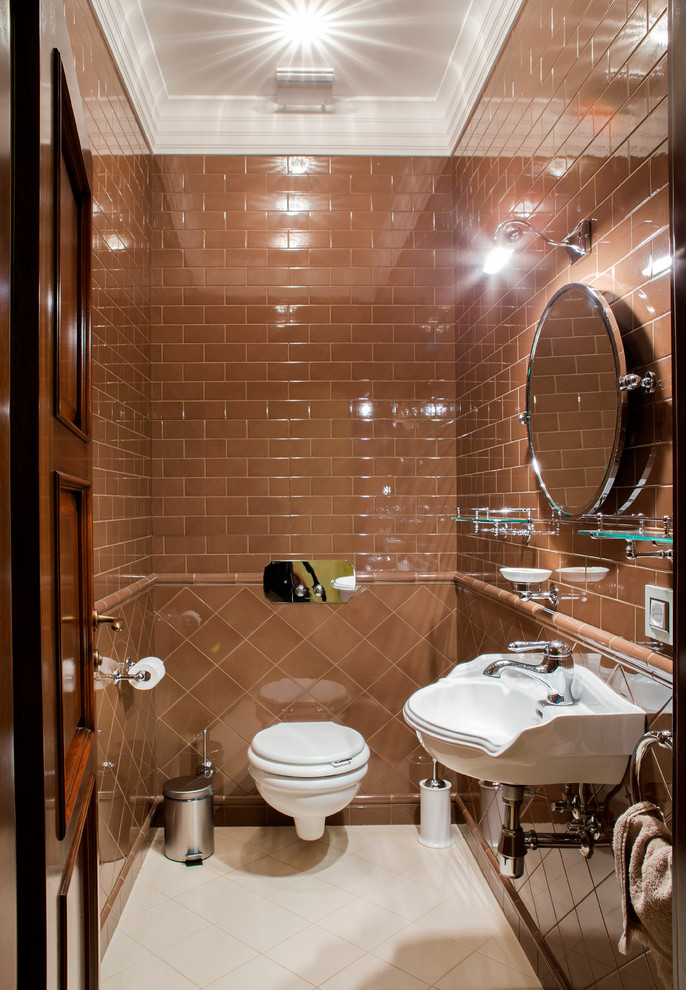 Свежая идея для дизайна: туалет в классическом стиле с инсталляцией, коричневой плиткой, коричневыми стенами и подвесной раковиной - отличное фото интерьера