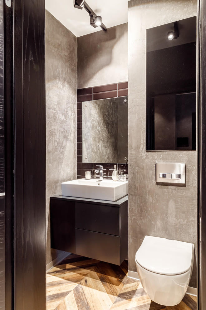 Стильный дизайн: туалет среднего размера в стиле лофт с инсталляцией, керамической плиткой, серыми стенами, полом из керамогранита, столешницей из искусственного камня, коричневым полом, серой столешницей и настольной раковиной - последний тренд