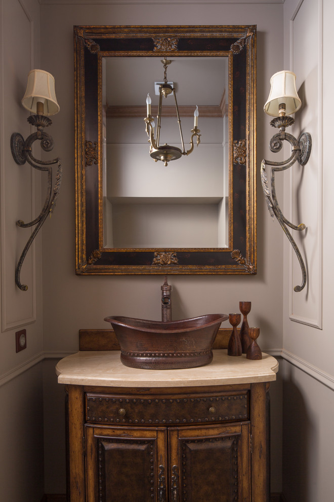 Immagine di un bagno di servizio tradizionale con ante marroni, pareti beige, lavabo a bacinella e top beige