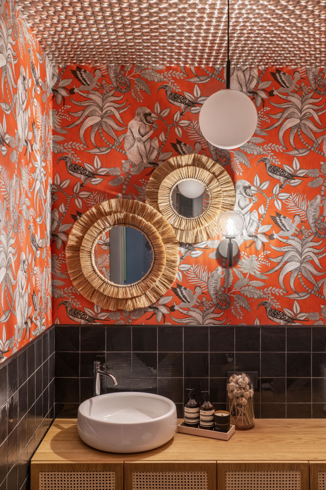 Modern inredning av ett stort brun brunt toalett, med luckor med infälld panel, skåp i ljust trä, svart kakel, keramikplattor, orange väggar, klinkergolv i keramik, ett nedsänkt handfat, träbänkskiva och brunt golv