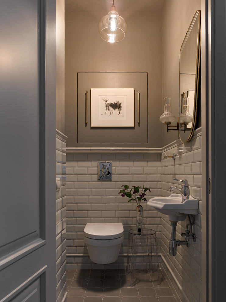 Exemple d'un petit WC suspendu chic avec un carrelage beige, un carrelage métro, un mur gris, un lavabo suspendu et un sol gris.
