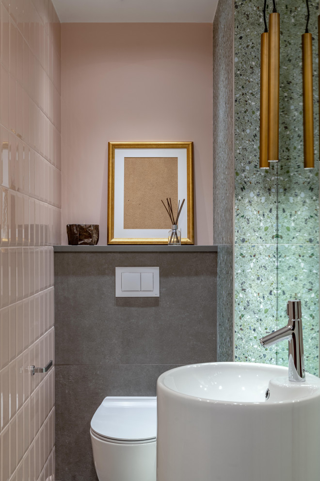 Idéer för små funkis grått toaletter, med en vägghängd toalettstol, rosa kakel, grå kakel, keramikplattor, rosa väggar, klinkergolv i porslin, bänkskiva i akrylsten, grått golv och ett piedestal handfat