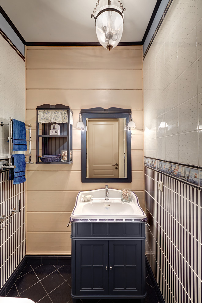 Modelo de aseo marinero con armarios con paneles empotrados, puertas de armario azules, baldosas y/o azulejos azules, baldosas y/o azulejos blancos y lavabo integrado
