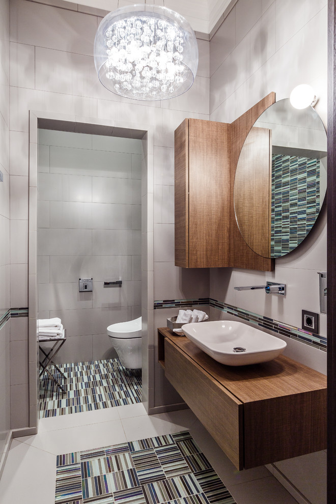Idee per un bagno di servizio design con ante lisce, ante in legno scuro, lavabo a bacinella e WC sospeso