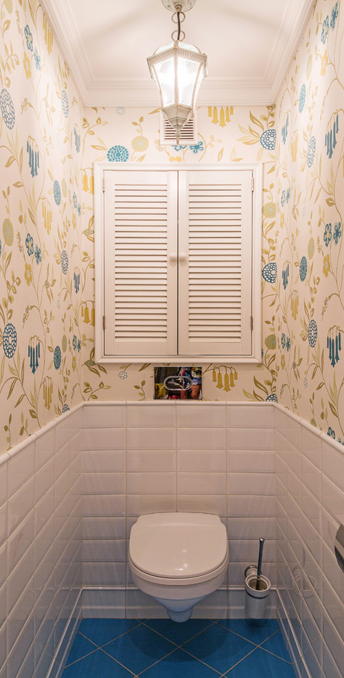 Idee per un bagno di servizio tradizionale con WC sospeso, piastrelle blu, piastrelle bianche, pareti multicolore e pavimento blu