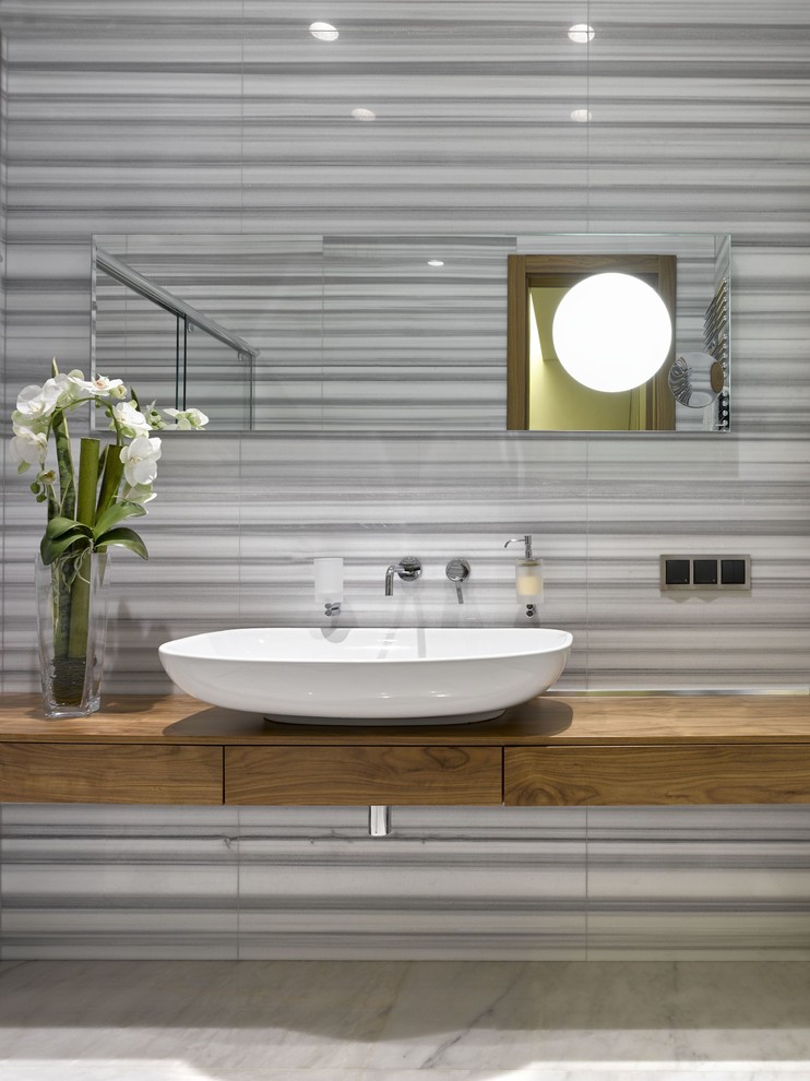 Immagine di un bagno di servizio design di medie dimensioni con ante lisce, ante in legno scuro, pistrelle in bianco e nero, piastrelle di marmo, pavimento in marmo, top in legno e lavabo a bacinella
