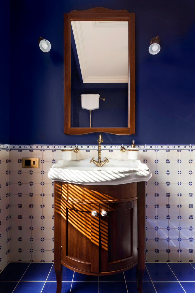 Пример оригинального дизайна: туалет в классическом стиле с фасадами островного типа, темными деревянными фасадами, синей плиткой, синими стенами и монолитной раковиной