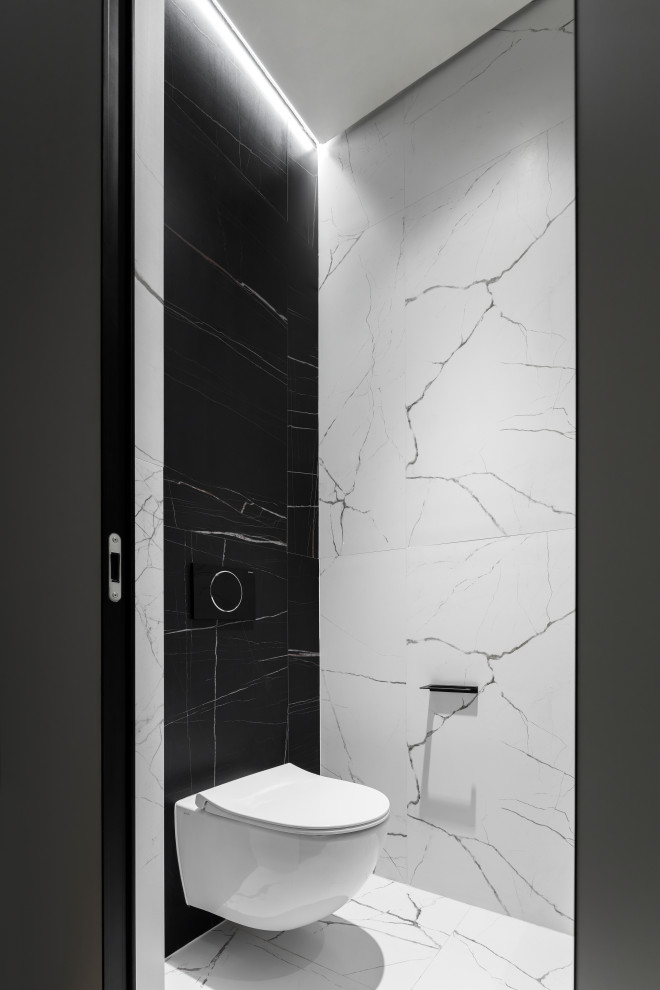 Foto på ett litet funkis toalett, med en vägghängd toalettstol, svarta väggar, marmorgolv och vitt golv