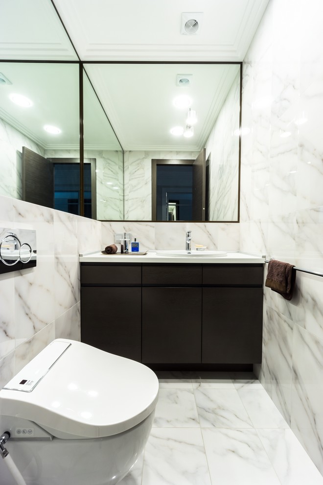 На фото: туалет в современном стиле с плоскими фасадами, черными фасадами, серой плиткой и накладной раковиной с