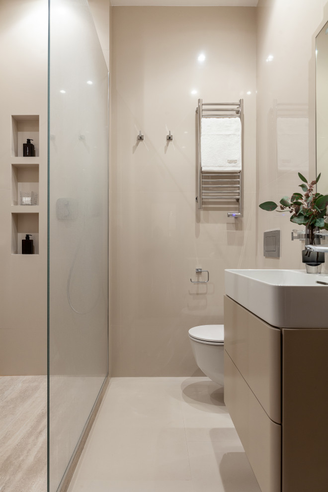 Idee per un bagno di servizio contemporaneo con ante lisce, ante beige, WC sospeso, piastrelle beige, lavabo integrato e pavimento beige