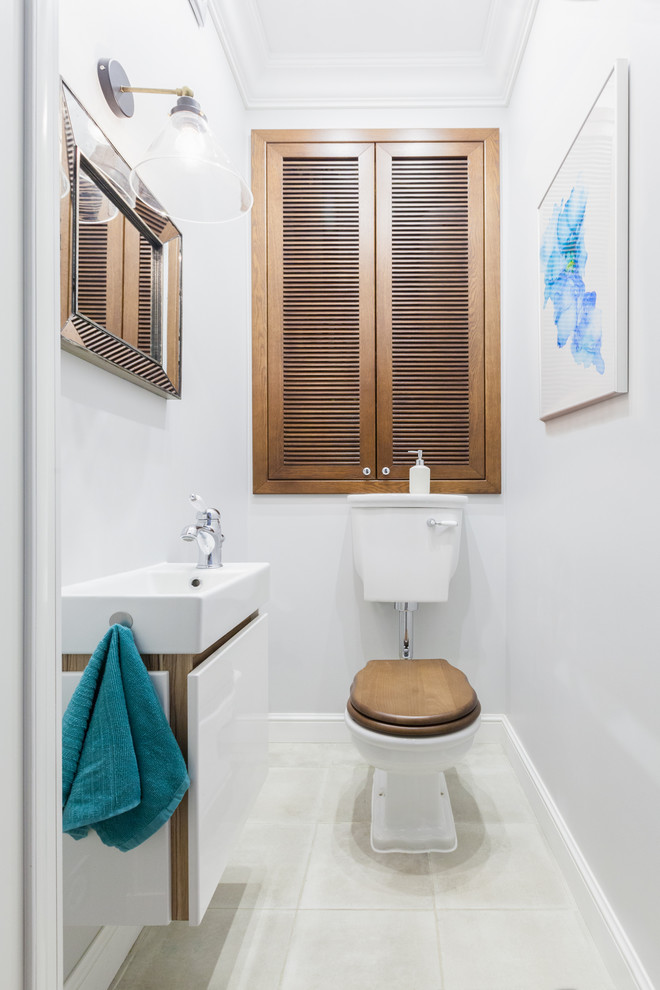 Ispirazione per un bagno di servizio minimal con ante lisce, ante bianche, WC a due pezzi, pareti bianche, pavimento bianco e lavabo da incasso