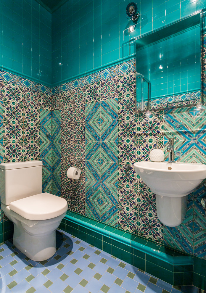 Immagine di un bagno di servizio bohémian con WC a due pezzi, piastrelle blu e lavabo sospeso