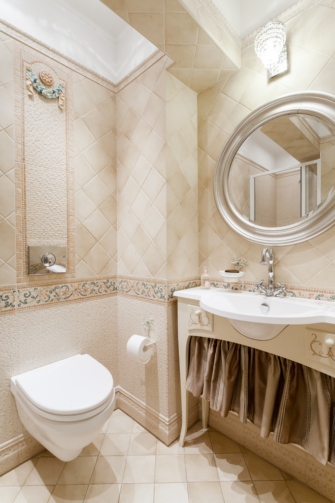 Cette image montre un WC suspendu traditionnel avec des portes de placard beiges, un carrelage beige et un lavabo posé.