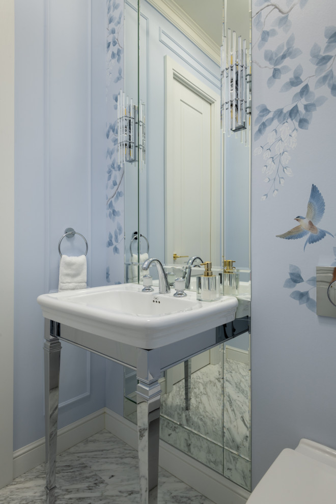 Ispirazione per un piccolo bagno di servizio classico con pareti blu, pavimento in marmo, lavabo a consolle, pavimento bianco, mobile bagno freestanding, carta da parati e WC sospeso