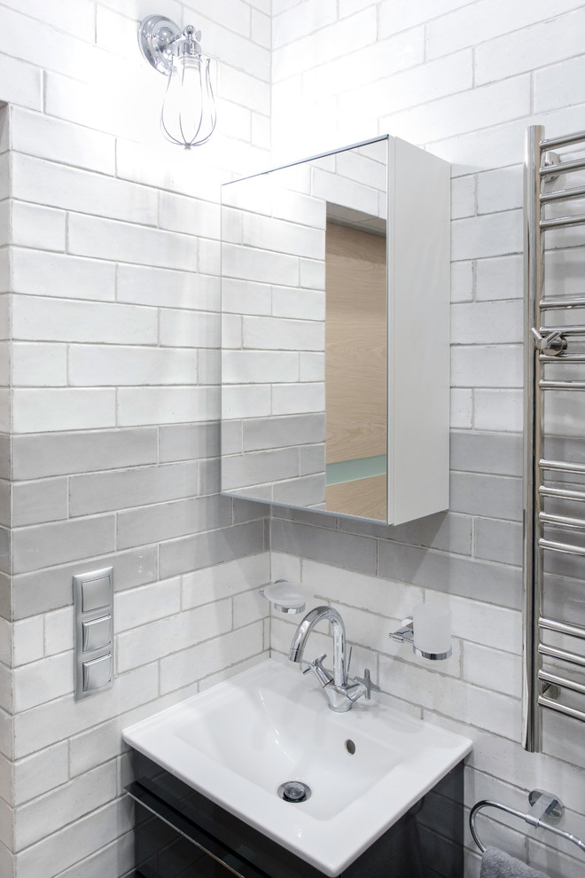 Idées déco pour un petit WC suspendu scandinave en bois clair avec un placard à porte plane, un carrelage gris, un carrelage métro, un mur gris, un sol en carrelage de porcelaine, un lavabo de ferme et un sol gris.