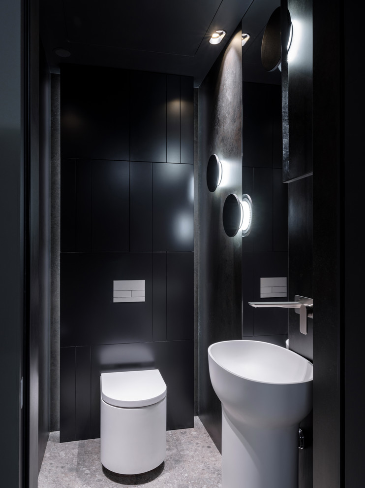 Idéer för funkis toaletter, med en vägghängd toalettstol, ett piedestal handfat, grått golv, svart kakel och svarta väggar