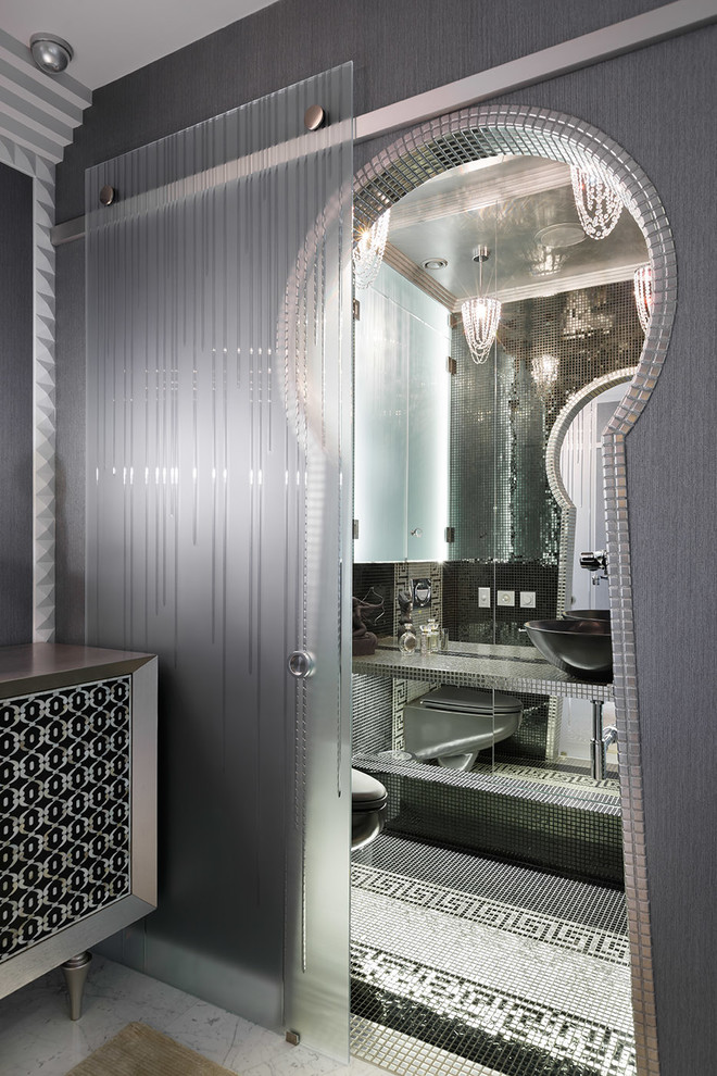 На фото: туалет в стиле фьюжн с зеркальной плиткой, полом из мозаичной плитки и настольной раковиной с