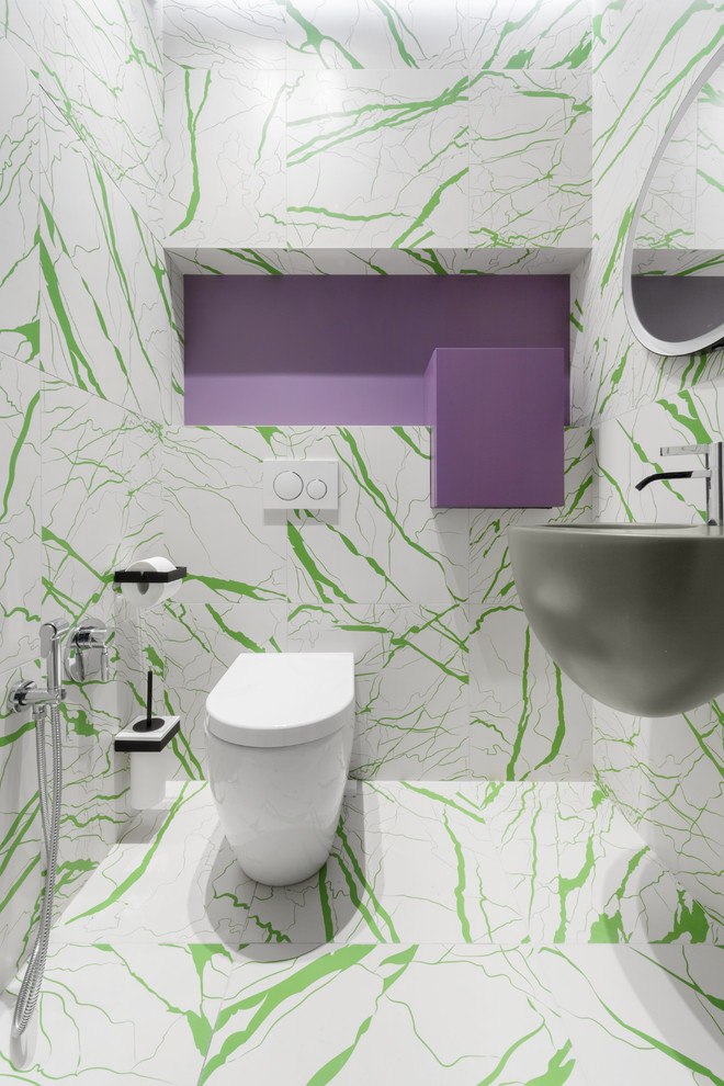 На фото: туалет в современном стиле с раздельным унитазом, белой плиткой, зеленой плиткой, подвесной раковиной и разноцветным полом с