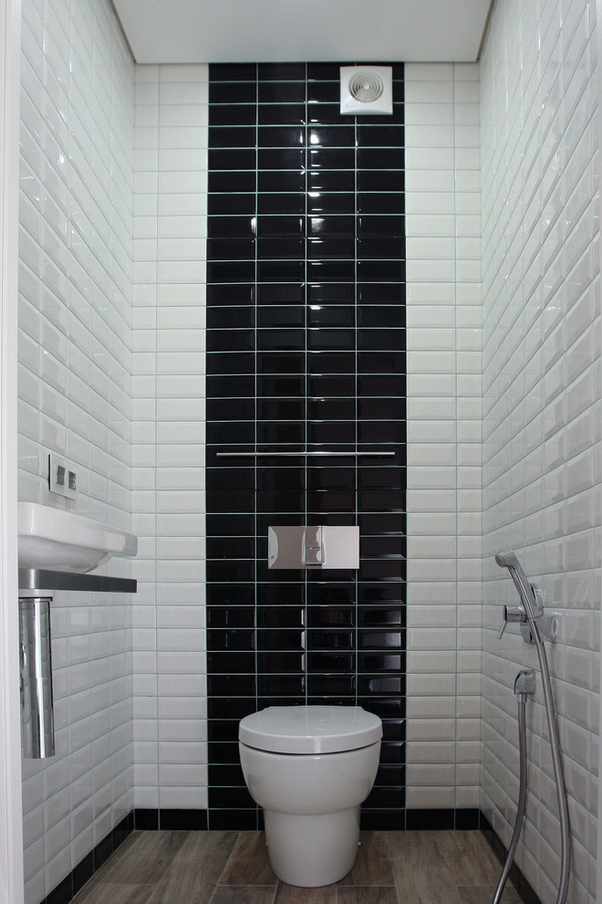 Small trendy white tile, black tile and ceramic tile medium tone wood floor powder room photo in Moscow with a two-piece toilet and a wall-mount sink