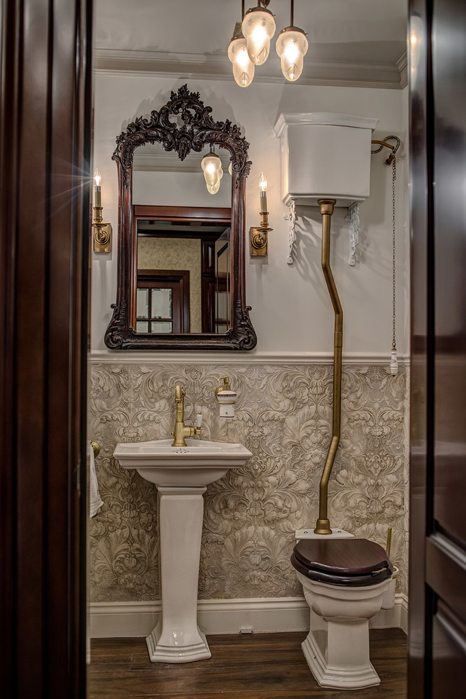 Inredning av ett klassiskt toalett, med en toalettstol med separat cisternkåpa, ett piedestal handfat och beige väggar